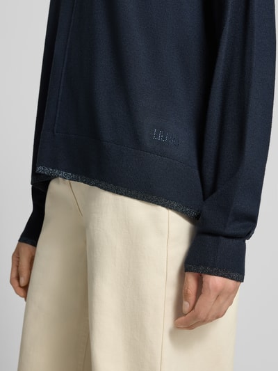 Frauenmodel trägt Relaxed Fit Pullover aus Viskose-Mix Modell 'MAGLIA CHIUSA' von Liu Jo White, Strick-Optik, Logo-Detail, Nahaufnahme Oberkörper.
