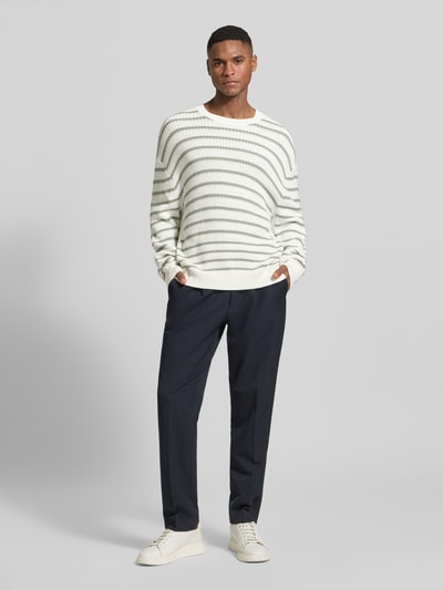 Männermodel trägt Strickpullover mit Rundhalsausschnitt von ARMANI EXCHANGE aus Baumwolle, Offwhite mit dunklen Streifen, Relaxed Fit, Ganzkörperansicht von vorne