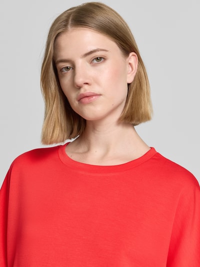 Frauenmodel trägt T-Shirt mit Rundhalsausschnitt Modell 'BANU' von Soyaconcept in leuchtendem Rot, glatte Textur, Nahaufnahme Oberkörper. Damen T-Shirt mit Relaxed Fit, Material-Mix mit Modal-Anteil.