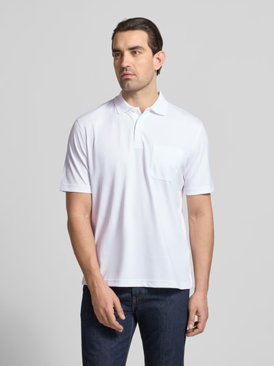 Männermodel trägt Regular Fit Poloshirt mit Brusttasche von Christian Berg Men aus Baumwoll-Mix, Polokragen, Knopfleiste, Ganzkörperansicht von vorne.