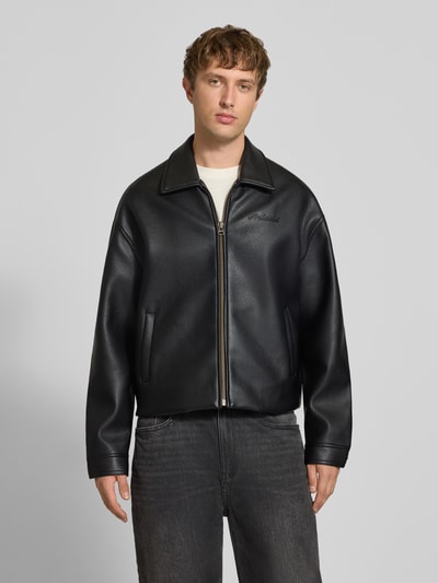 Männermodel trägt Jacke in Leder-Optik Modell 'NIGHTRIDER' von PROHIBITED, schwarz, Regular Fit, Ganzkörperansicht von vorne, Kontext: Herren Jacke von PROHIBITED, Leder-Optik, Modell 'NIGHTRIDER', Logo, Reißverschluss, Rückenlänge bei Größe M: 65 cm, Schulterbreite bei Größe M: 54 cm, Brustweite bei Größe M: 62 cm, Ärmellänge bei Größe M: 62 cm.
