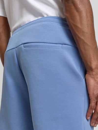 Mężczyzna nosi Regular Fit Sweatshorts aus Baumwoll-Mix Modell 'JT_GLOBE' von BOSS Green, efekt: jednolity kolor, bawełniany materiał, detal: szwy, wpuszczane kieszenie, tylna perspektywa, zbliżenie na dolną część pleców.