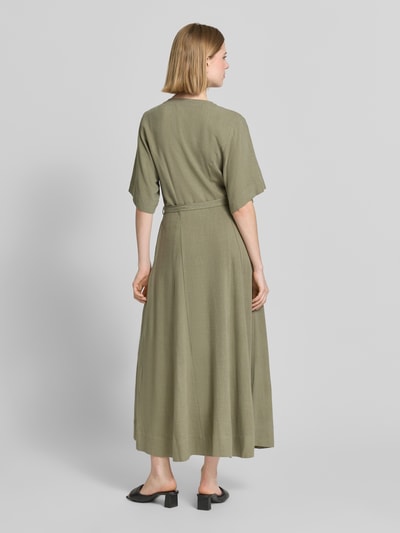 Modelka nosi Regular Fit Leinenkleid mit V-Ausschnitt Modell 'VIVA' von Selected Femme, zielony, krój regular fit, len z wiskozą, maxi, bez rękawów, pasek, kieszenie, widok całej sylwetki z tyłu.