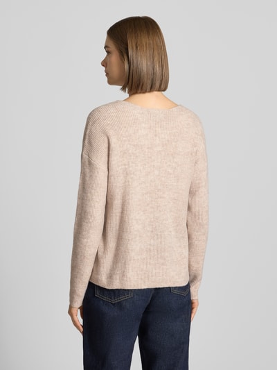 Frauenmodel trägt Regular Fit Pullover mit V-Ausschnitt Modell 'CAMILLA' von ONLY in Beige, strukturierte Oberfläche, Damen Pullover, Ganzkörperansicht Rückansicht.