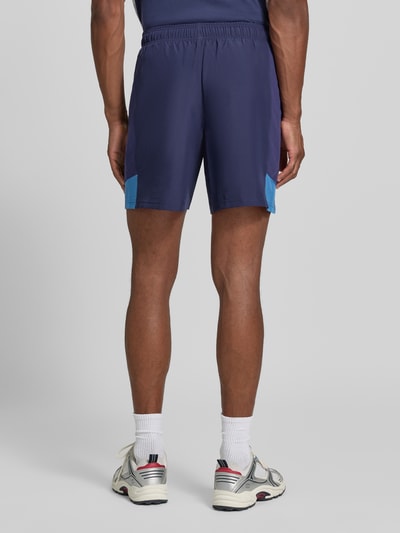 Männermodel trägt donkerblau Regular Fit Sportshorts met elastische band model 'UTILITY' van Under Armour, Ganzkörperansicht Rückansicht.