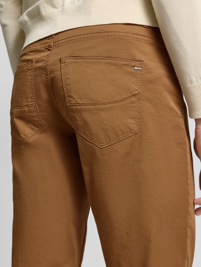 Mężczyzna nosi Regular Fit Stoffhose mit Lyocell-Anteil Modell 'Cadiz' od Brax w kolorze karmelowym, z 5 kieszeniami, bawełniano-lyocellowa tkanina, szerokość w rozmiarze 32/32: 107 cm, długość nogawki: 81 cm, zdjęcie z tyłu, zbliżenie na biodra i pośladki.