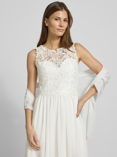 Kobiece modelka nosi Brautkleid mit floraler Spitze od Mascara, taliowany krój, szerokie ramiączka, dekolt w kształcie serca, półprzezroczysty materiał wierzchni, halka pod sukienkę, wszyty zamek błyskawiczny i haftki, z przodu jasne kolory, kwiatowa faktura koronki, rozmiar 36: długość tyłu 107 cm, szerokość klatki piersiowej 40 cm.
Nahaufnahme górnej części ciała.