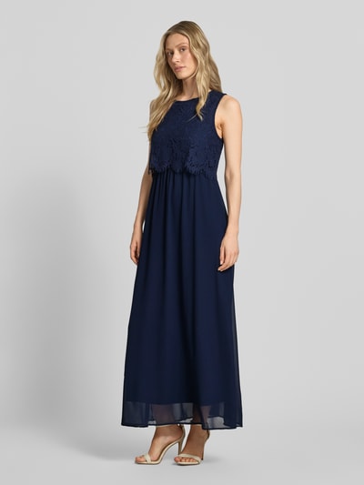 Frauenmodel trägt Maxikleid mit rückseitigem Schlüsselloch-Ausschnitt von Vila in Dunkelblau, Baumwoll-Mix, Spitze, Gerader-Schnitt, Ganzkörperansicht von vorne.