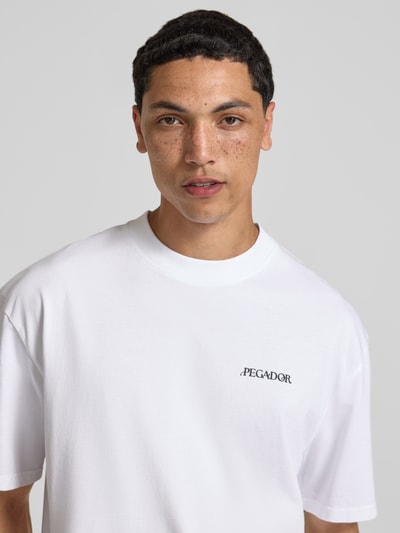 Männermodel trägt weißes Oversized T-shirt mit labelprint Modell 'Miles' von Pegador aus puur katoen, ronde hals, Nahaufnahme Oberkörper