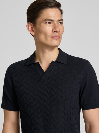 Männermodel trägt Regular Fit Poloshirt mit Strukturmuster Modell 'DYRVIK' von Casual Friday, dunkle Farbe, reine Baumwolle, Nahaufnahme Oberkörper.