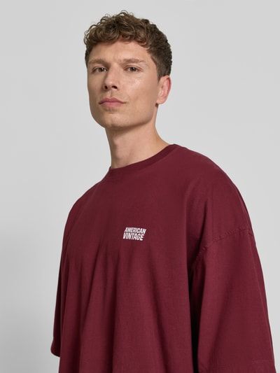 Männermodel trägt Herren T-Shirt mit Logo-Print, Modell 'GIXY' von American Vintage in Reine Baumwolle, Loose-Fit, Nahaufnahme Oberkörper.