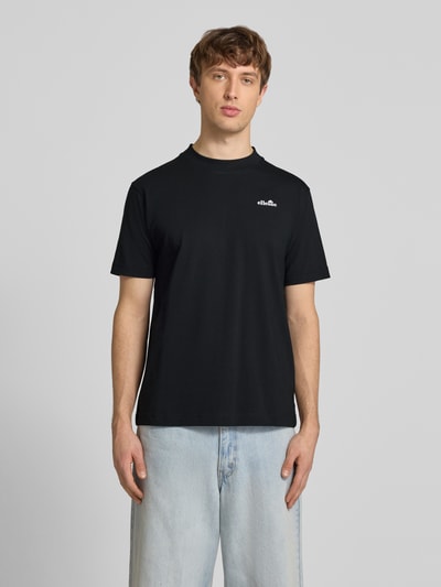 Męski model nosi czarny t-shirt z wyhaftowanym logo, model 'ACCIANO CLASSIC' od Ellesse, bawełna, prosty krój, stójka, Ganzkörperansicht von vorne.