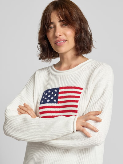 Vrouwenmodel draagt gebreide pullover met ronde hals en Amerikaans vlagmotief, puur katoen, regular fit, grof tricot van GAP, close-up bovenlichaam.