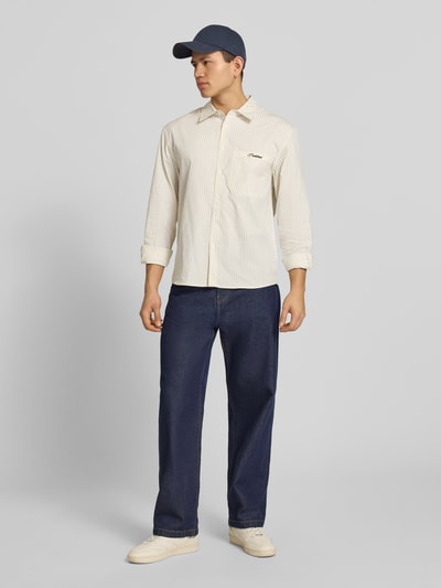 Männermodel trägt Regular Fit Freizeithemd mit Kentkragen Modell 'Drift' von PROHIBITED in Beige mit feinen Streifen und Brusttasche, Baumwolle, Ganzkörperansicht von vorne.