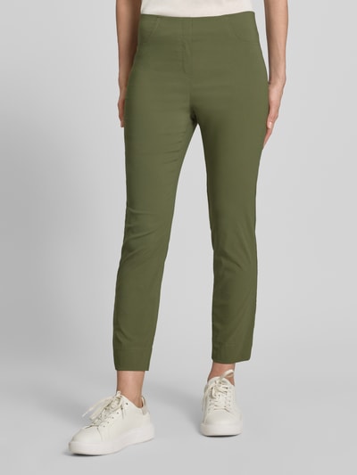 Frauenmodel trägt Caprihose aus Viskose-Mix Modell 'Igor3' von STEHMANN in Olivgrün, Slim-Fit mit Stretch-Anteil, Nahaufnahme Unterkörper. Bundweite bei Größe 36: 38 cm, Innenbeinlänge: 69 cm.