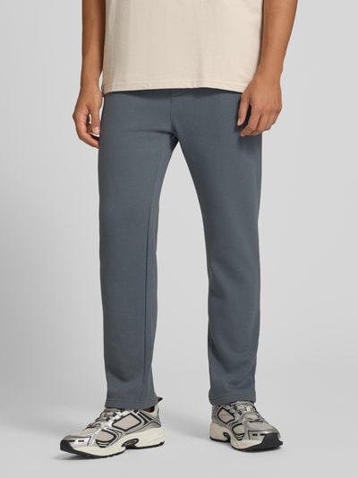 Männermodel trägt Straight Fit Sweatpants Modell 'BRADLEY' von JACK & JONES, graublauer Farbton, Baumwoll-Mix, Ganzkörperansicht von vorne.