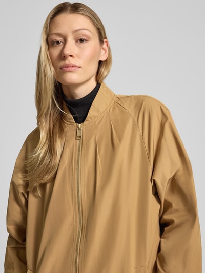 Frauenmodel trägt Mantel mit Stehkragen und Zweiwege-Reißverschluss von Fuchs Schmitt in Beige, Material-Mix, Nahaufnahme Oberkörper.