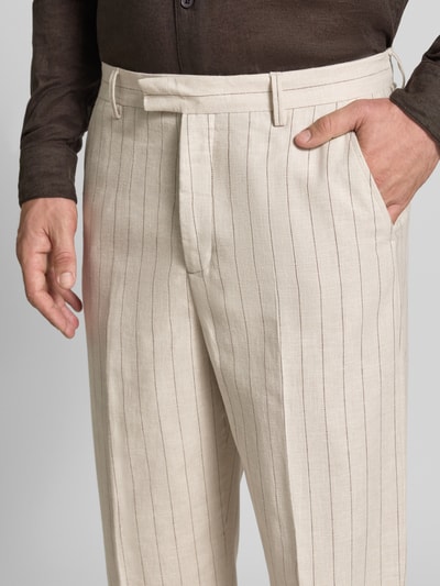 Männermodel trägt Relaxe Fit Anzughose aus Leinen-Bumwoll-Mix Modell 'LADATTI' von Selected Homme, cremefarben mit feinen Streifen, Nahaufnahme Oberkörper. Herren Anzughose von Selected Homme.
