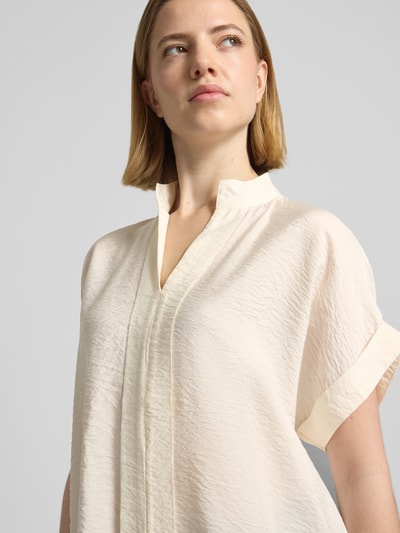Vrouwenmodel draagt Regular Fit blouse uit viscosemix met V-hals van Christian Berg Woman in lichte crèmekleur, opstaande kraag, ruglengte bij maat 36 is 72 cm, mouwlengte bij maat 36 is 28 cm, textuur met lichte kreuk, Nahaufnahme bovenlichaam