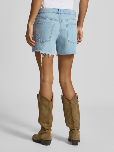 Frauenmodel trägt Regular Fit Jeansshorts aus reiner Baumwolle von REVIEW in Destroyed-Look, 5-Pocket-Design, hellblau, Ganzkörperansicht Rückansicht.