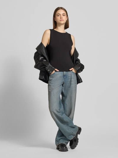 Frauenmodel trägt Top mit Rundhalsausschnitt Modell 'MOLLY' von Noisy May aus Baumwoll-Elasthan-Mix, Slim-Fit, Label-Detail, Rückenlänge 52 cm bei Größe S, einfarbig, glatte Textur, Ganzkörperansicht von vorne.