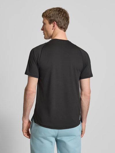 Männermodel trägt T-Shirt mit Label-Print von PUMA PERFORMANCE in Schwarz, Material-Mix mit Stretch-Anteil, Regular-Fit, Ganzkörperansicht Rückansicht.