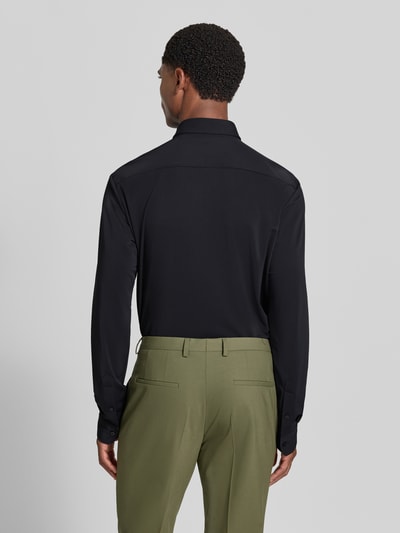 Männermodel trägt schwarzes Slim Fit Businesshemd mit Kentkragen Modell 'P-Roan' von BOSS, kombiniert mit olivgrüner Hose, Ganzkörperansicht Rückansicht, Herren Businesshemd von BOSS.