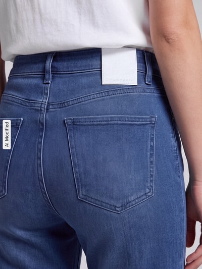Frauenmodel trägt Barrel Jeans aus Baumwoll-Mix Modell 'Mari Cosmo' von OPUS PANTS in mittlerem Blau mit sichtbarer Gesäßtasche, Nahaufnahme Rückansicht, Damen Barrel Jeans von OPUS PANTS, KI-modifiziertes Bild.