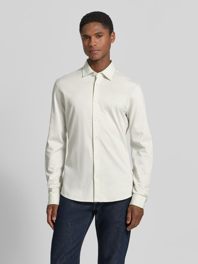 Männermodel trägt weißes Slim-Fit Freizeithemd aus Baumwolle, schlichtes Design, kombiniert mit dunkler Jeans, Modell 'MYSOFT_2' von BOSS Orange, Ganzkörperansicht von vorne.