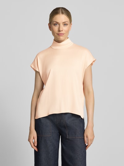 Frauenmodel trägt Blusenshirt mit Stehkragen Modell 'ALARIA' von DRYKORN in Pfirsich, glatte Struktur, Regular Fit, Ganzkörperansicht von vorne. Material-Mix mit Stretch-Anteil, Rückenlänge bei Größe 36: 60 cm.