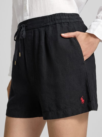 Vrouwenmodel draagt Regular Fit Leinenshorts met Tunnelzug van Polo Ralph Lauren, look: effen, bandplooi, logostitching, elastisch, tunnelkoord, zij- en achterzakken, materiaal: linnen. Detailopname heup.