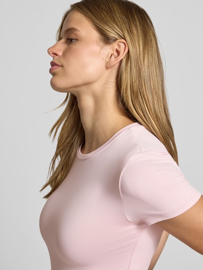 Vrouwenmodel draagt lichtroze slim fit t-shirt met ronde hals model 'LULA' van PIECES, dames t-shirt, close-up bovenlichaam
