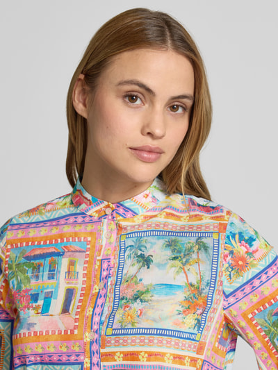 Frauenmodel trägt Knielanges Kleid aus reiner Viskose von Emily Van den Bergh mit buntem Muster, Stehkragen, Knopfleiste, 3/4-Arm, lockere Passform, Rückenlänge bei Größe 36: 103 cm, Brustweite bei Größe 36: 49 cm, Ärmellänge bei Größe 36: 40 cm, Nahaufnahme Oberkörper.