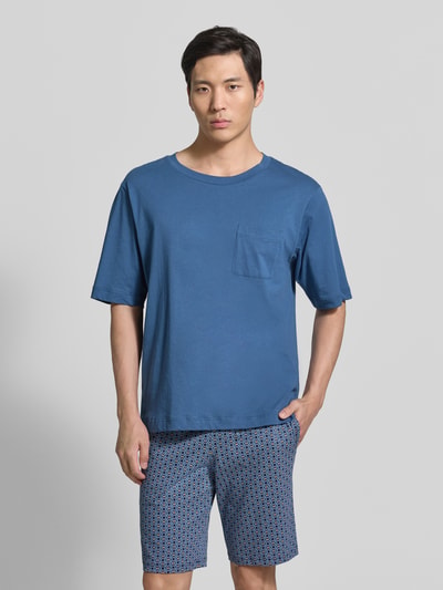 Męski model nosi T-Shirt mit Rundhalsausschnitt und Brusttasche od Schiesser, mieszanka bawełny i lnu, krój regular fit, okrągły dekolt, brustasza, długość tyłu w rozmiarze 50: 70 cm, widok na cały przód.