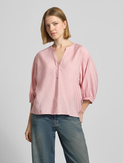 Frauenmodel trägt Regular Fit Bluse aus Viskose-Mix mit 3/4-Arm von Christian Berg Woman in Rosa, V-Ausschnitt, strukturierte Textur, Ganzkörperansicht von vorne. Rückenlänge bei Größe 36: 59 cm, Ärmellänge: 35 cm.