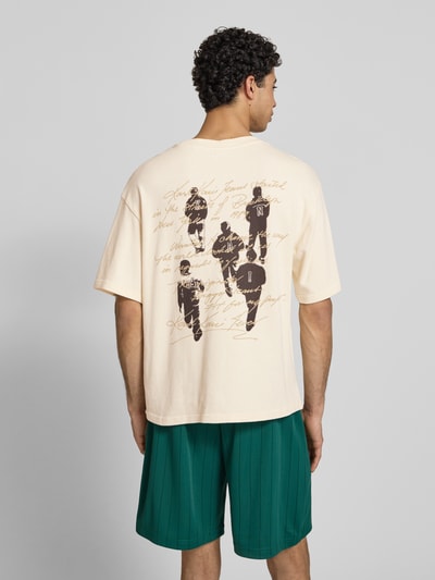 Männermodel trägt Oversized T-Shirt mit Logo-Stitching von KARL KANI aus Reine Baumwolle, Oversized-Fit, Rundhalsausschnitt, Rückenlänge 65 cm, Herren T-Shirt, Ganzkörperansicht Rückansicht.