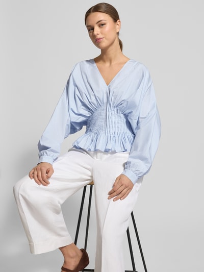 Kobiece model nosi Bluzka z dekoltem w serek Model 'POPLIN' od Copenhagen Muse z bawełny, taliowany krój, jasnoniebieska, zdjęcie całej sylwetki z przodu.