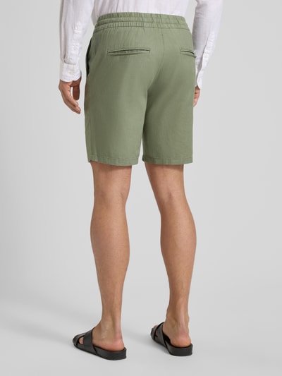 Männermodel trägt Shorts aus Leinen-Baumwoll-Mix Modell 'barton' von Matinique in Grün, Regular-Fit, elastischer Bund mit Tunnelzug, Rückansicht, Kontext: Herren Shorts, Bundweite bei Größe M 43 cm, Innenbeinlänge 21 cm.