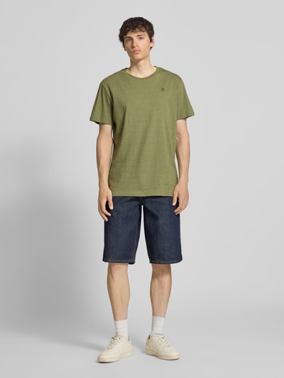 Männermodel trägt T-Shirt mit Logo und Rundhalsausschnitt von G-Star Raw in Oliv, Reine Baumwolle, Regular-Fit, Rückenlänge 76 cm, Ganzkörperansicht von vorne.