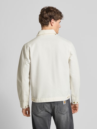 Männermodel trägt Jacke mit Label-Detail Modell 'Detroit' von Carhartt Work In Progress in Offwhite, reine Baumwolle, Rückenansicht Ganzkörperansicht.