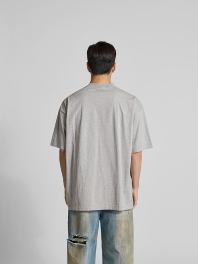 Männermodel trägt T-Shirt mit Rundhalsausschnitt von VETEMENTS, Herren T-Shirt aus Reine Baumwolle, Lockerer-Schnitt, Rückenlänge 79 cm, Ganzkörperansicht Rückansicht.