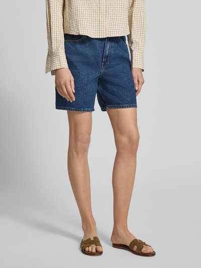 Frauenmodel trägt Straight Leg Bermudas aus reiner Baumwolle Modell 'EMI' von Tommy Hilfiger in Denim-Optik, Regular-Fit, mit Label-Patch, Logo-Applikation, Gürtelschlaufen, Knopf und verdecktem Reißverschluss, 5-Pocket-Design, reine Baumwolle, blaue Farbe, glatte Textur, Ganzkörperansicht von vorne.