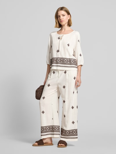 Frauenmodel trägt Bluse aus Viskose-Mix mit 3/4-Arm von Christian Berg Woman Selection, beige mit Ethnomuster, Straight Fit, Schlüsselloch-Ausschnitt mit Schnürung, elastischer Abschluss, Ganzkörperansicht von vorne.