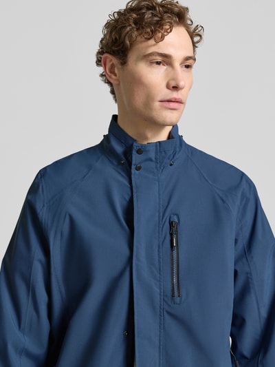 Männermodel trägt Jacke mit Napoleontasche Modell 'KOS' von Killtec in Blau, gerade Passform, Nahaufnahme Oberkörper.