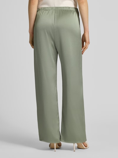 Frauenmodel trägt Wide Fit Hose aus Satin von Calvin Klein Womanswear in einfarbigem Hellgrün, elastischer Bund, Ganzkörperansicht Rückansicht.