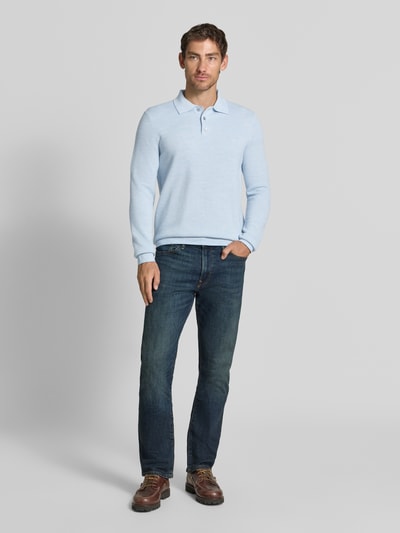 Mężczyzna nosi Regular Fit Poloshirt mit Woll-Anteil od Polo Ralph Lauren, jasnoniebieski kolor, gładka tekstura, pełny widok z przodu.