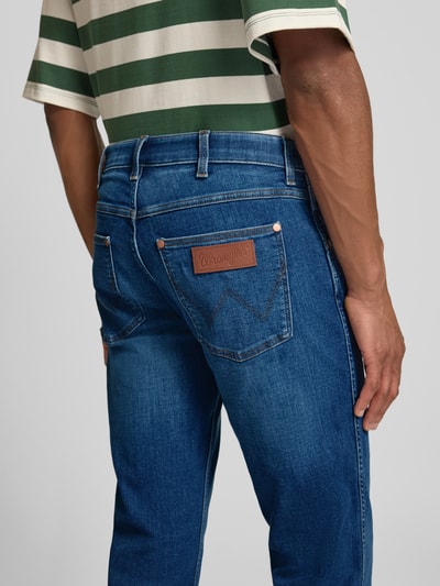 Männermodel trägt Straight Fit Jeans im 5-Pocket-Design Modell 'Greensboro' von Wrangler, blauer Baumwoll-Mix mit Stretch-Anteil, Gerader-Schnitt, Detailaufnahme Rückansicht.