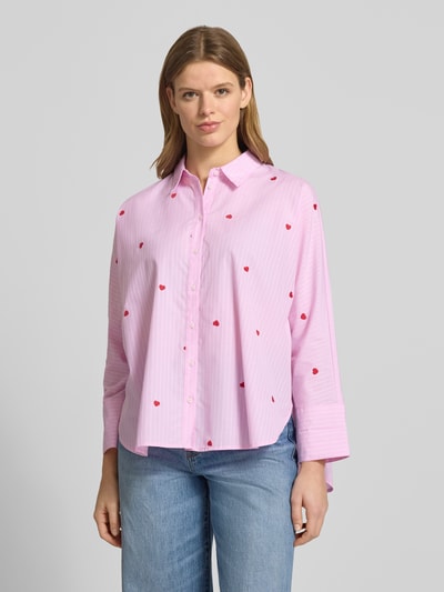 Modelka prezentuje bluzkę koszulową Relaxed Fit Hemdbluse mit Baumwoll-Anteil Modell 'NEW LINA GRACE' od Only, efekt: wzór w paski na całej powierzchni, hafty w kształcie serca, krój relaxed fit, kołnierzyk koszulowy, listwa guzikowa, długi rękaw z brzegiem, lekko zaokrąglone wykończenie dołu, jasnoróżowa z czerwonymi serduszkami, jednorodna faktura tkaniny, widok na całe ciało z przodu.