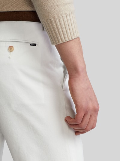 Männermodel trägt Slim Fit Chino aus Baumwoll-Mix von Polo Ralph Lauren in Unifarbe, mit Label-Detail, Nahaufnahme Oberkörper.
