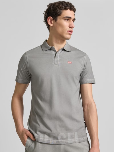 Männermodel trägt Regular Fit Poloshirt aus Baumwolle von Diesel in Grau mit Polokragen, Label-Details, Kurzärmelig, Ganzkörperansicht von vorne.